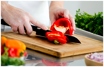 A chef cutting a bell pepper